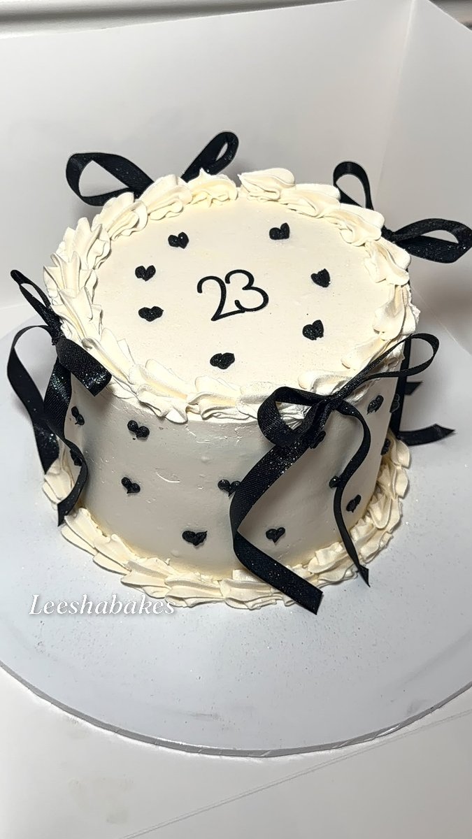 Cream cake with black bows, hearts and '23' message