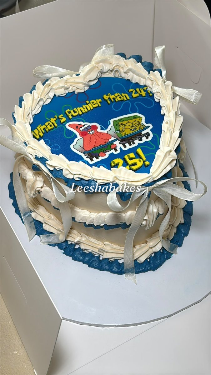 Blue and cream heart cake with a cartoon edible topper and 25th birthday message